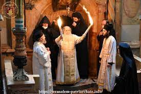 البطريرك الاورشليمي الارثوذكسي بيده شعلة النور المقدس من داخل القبر المقدس
