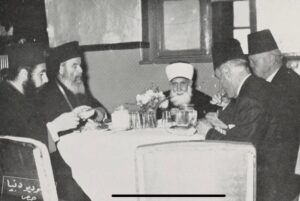 صورة نادرة من عام 1955 تجمع فضيلة الشيخ توفيق الأتاسي مفتي حمص (1940-1965) مع سيادة المتروبوليت ألكسندروس جحا مطران الروم بحمص (1940-1968) في أحد الاجتماعات الخيرية