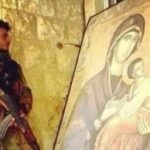 مقاتل من الجيش السوري يحتمي ويحامي عن ايقونة والدة الاله في الحرب الارهابية على سورية